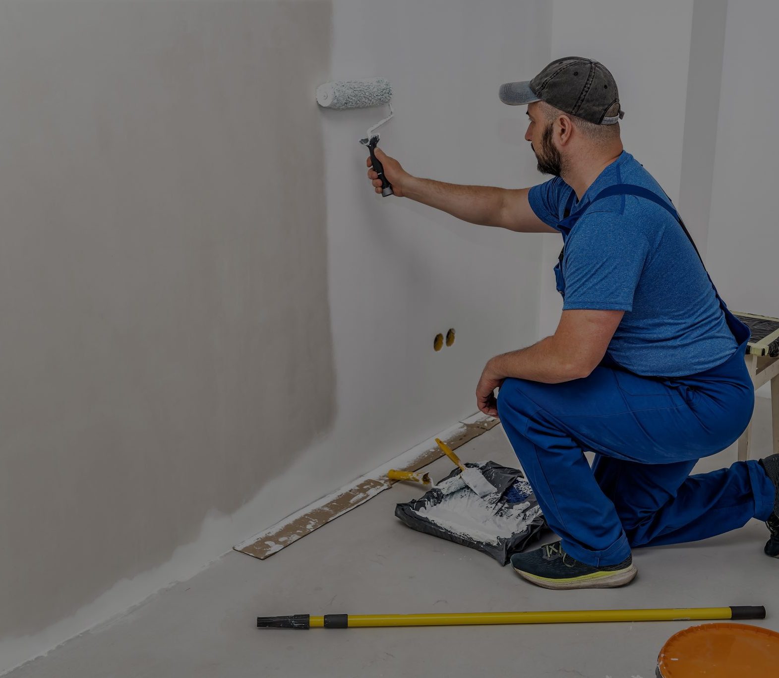 Mand maler væg med hvid maling